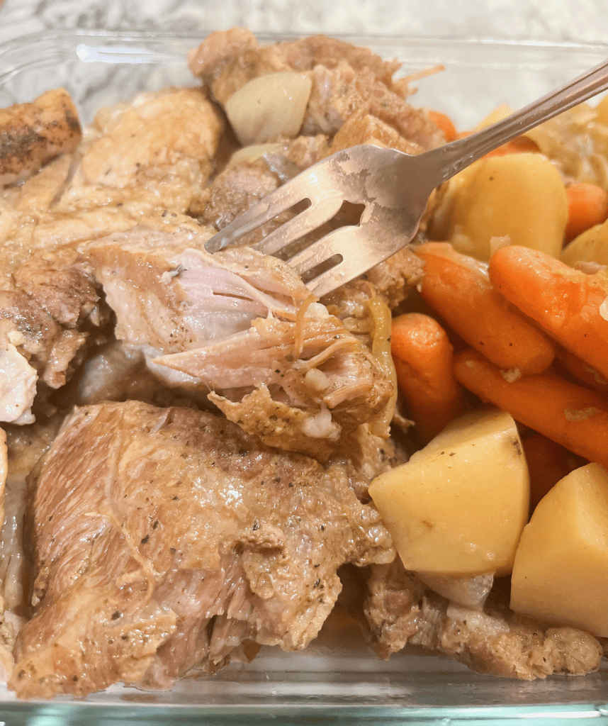 tender boston butt pork roast in dish with potatoes and carrots