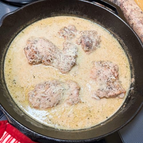 creamy lemon garlic chicken in a cast iron skillet