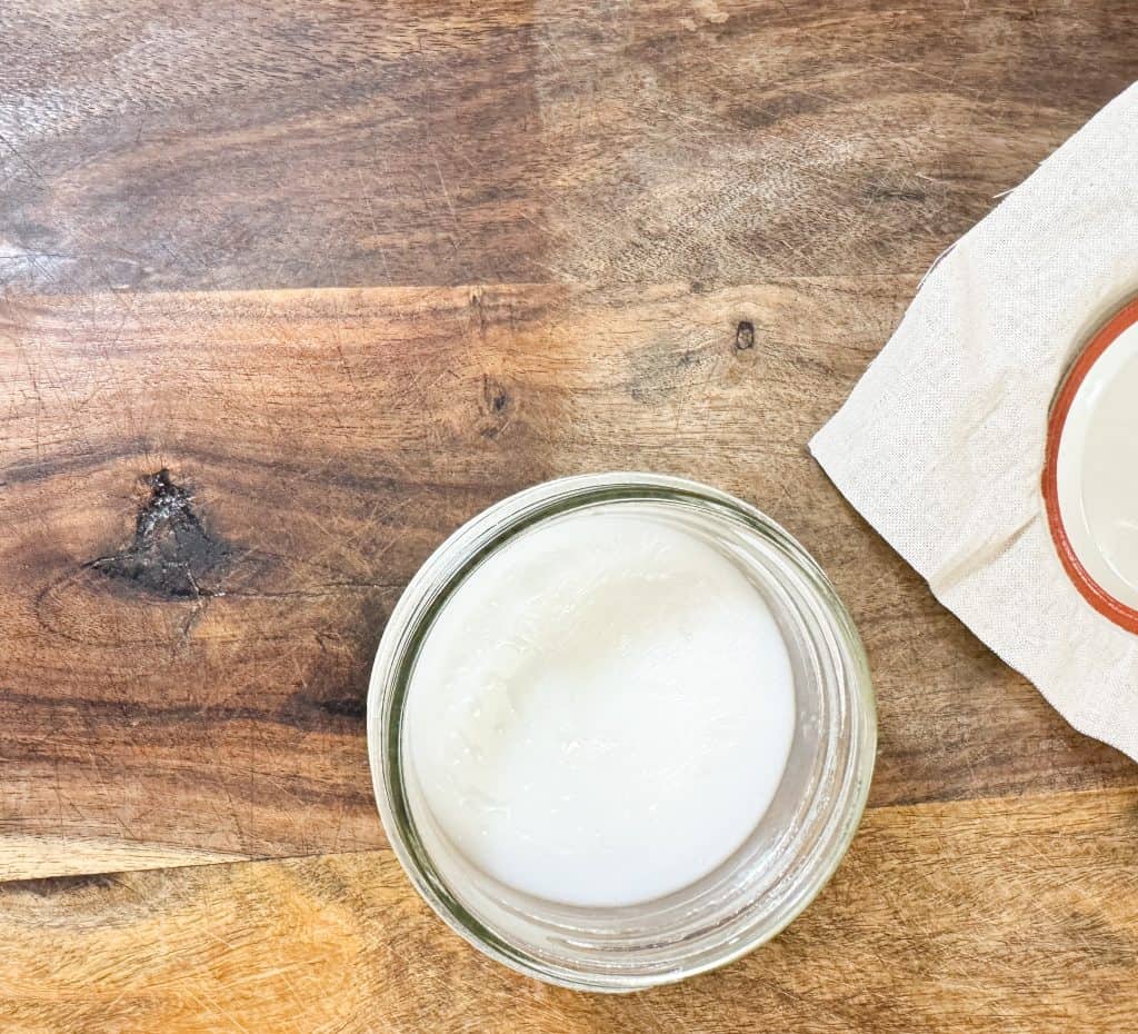 wood cutting board butter on a wooden cutting board with half of the board being coated and the other half not coated