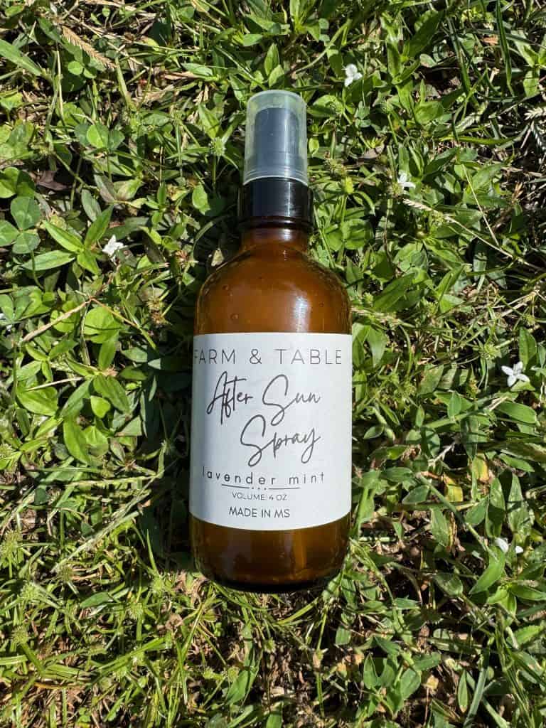 after sun spray in a 4oz amber bottle laying in the grass