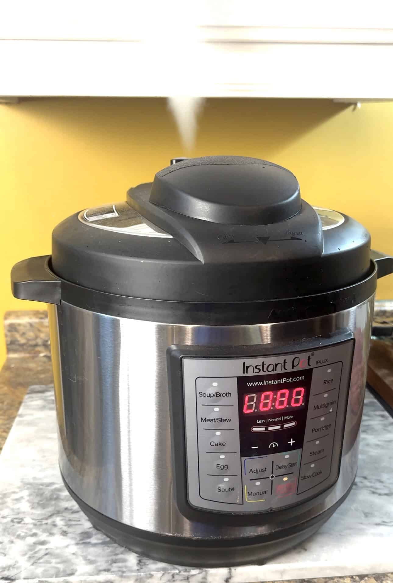 instant pot releasing steam on a marble board
