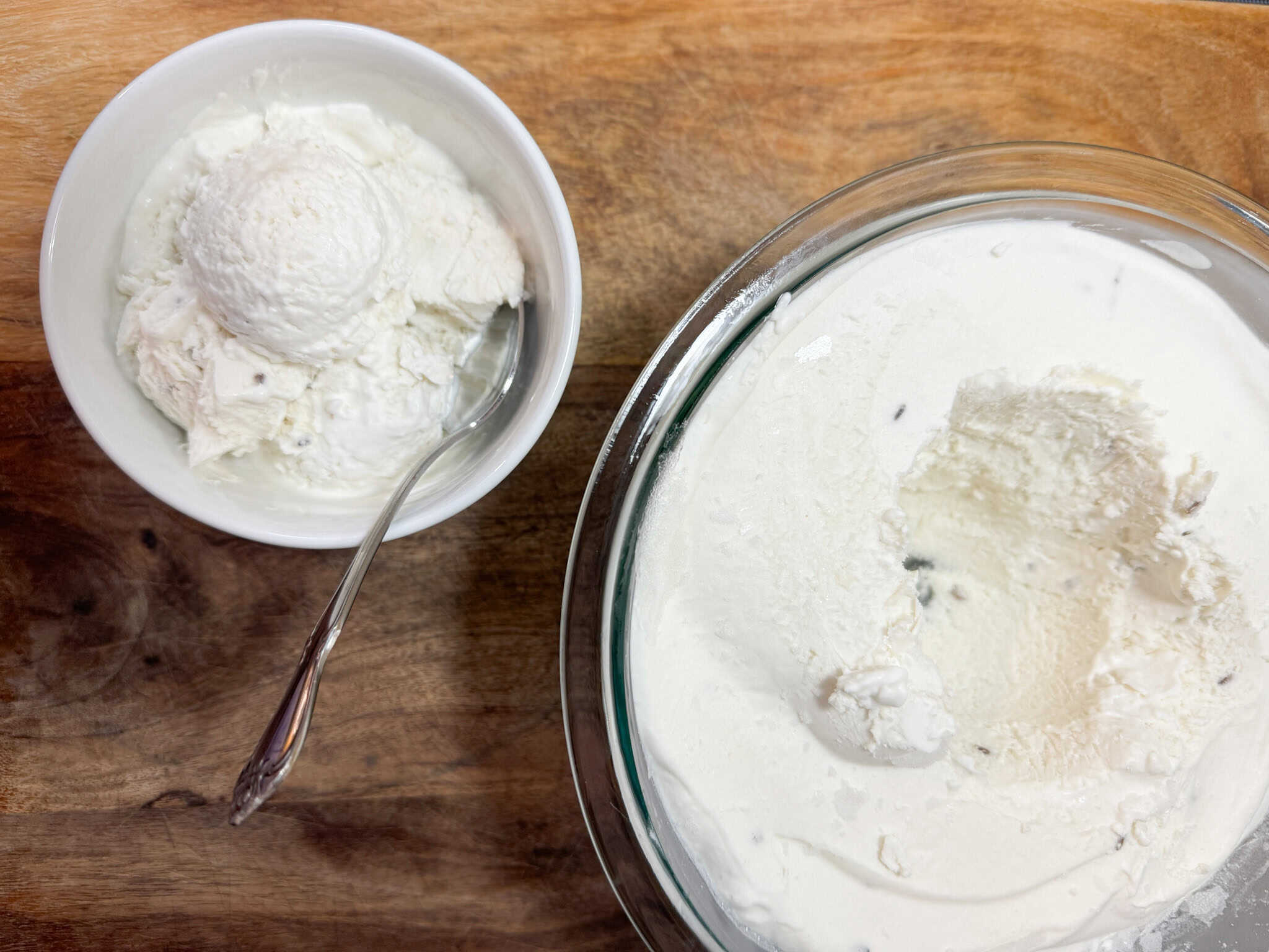 coconut lavender ice cream scooped from a large bowl to a smaller bowl