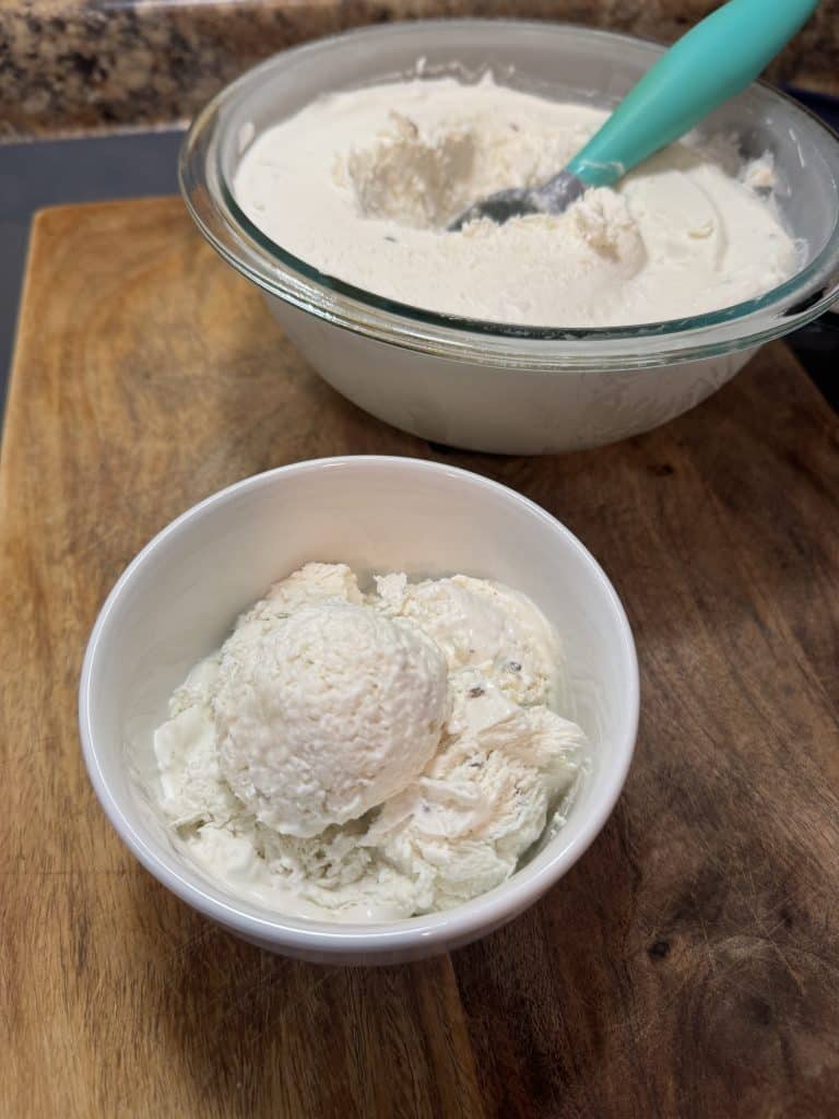 coconut lavender ice cream being scooped from a larger bowl to a smaller bowl