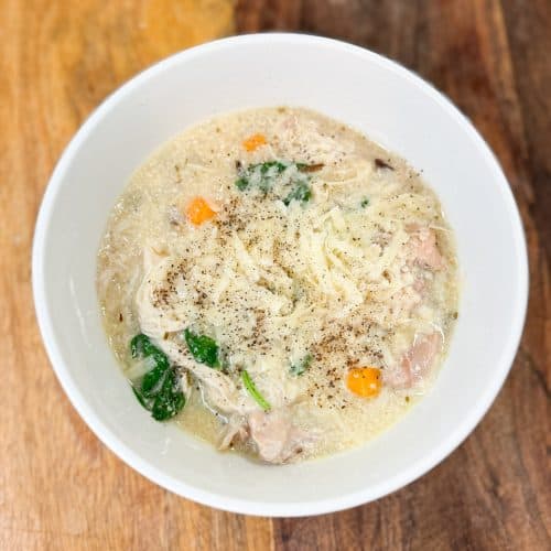 Instant pot creamy chicken and wild rice soup in a bowl on a wooden counter