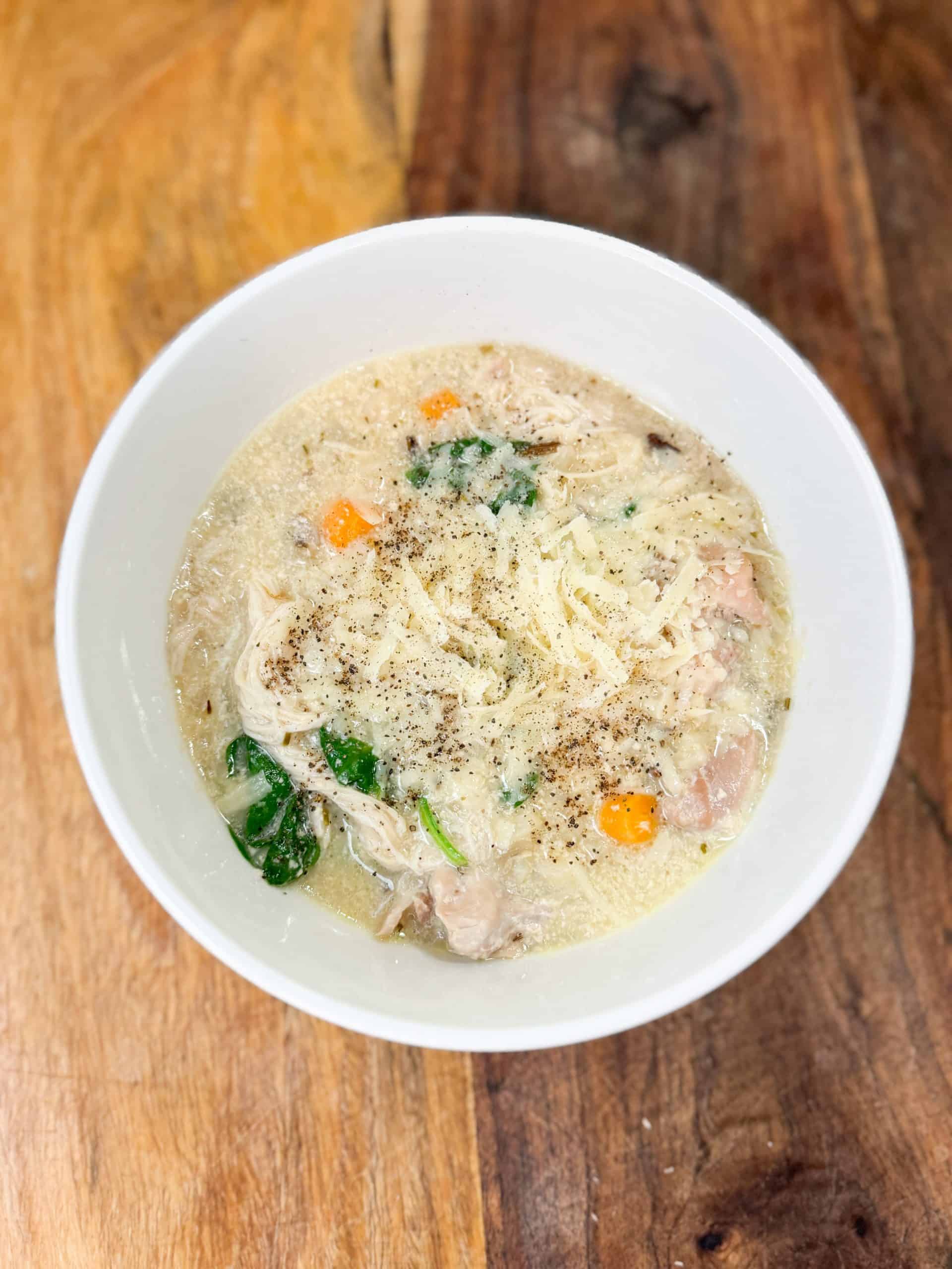 Instant pot creamy chicken and wild rice soup in a bowl on a wooden counter