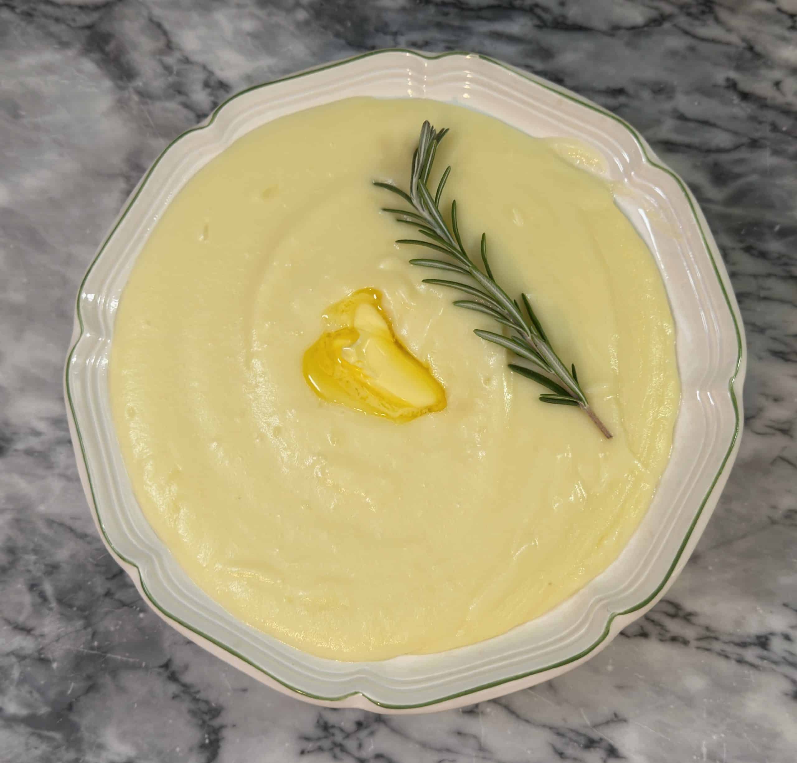 creamy garlic and rosemary mashed potatoes in a bowl on a marble counter