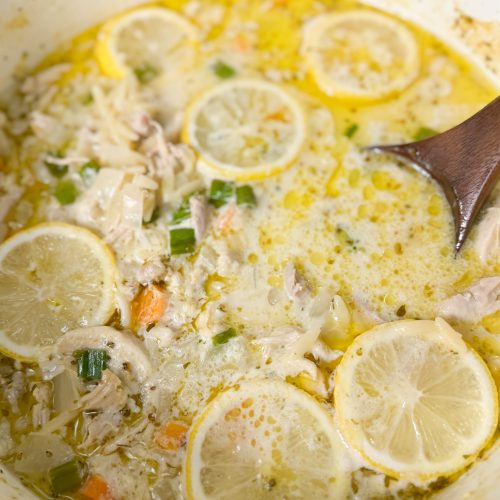 lemon chicken orzo soup in a dutch oven with a wooden spoon