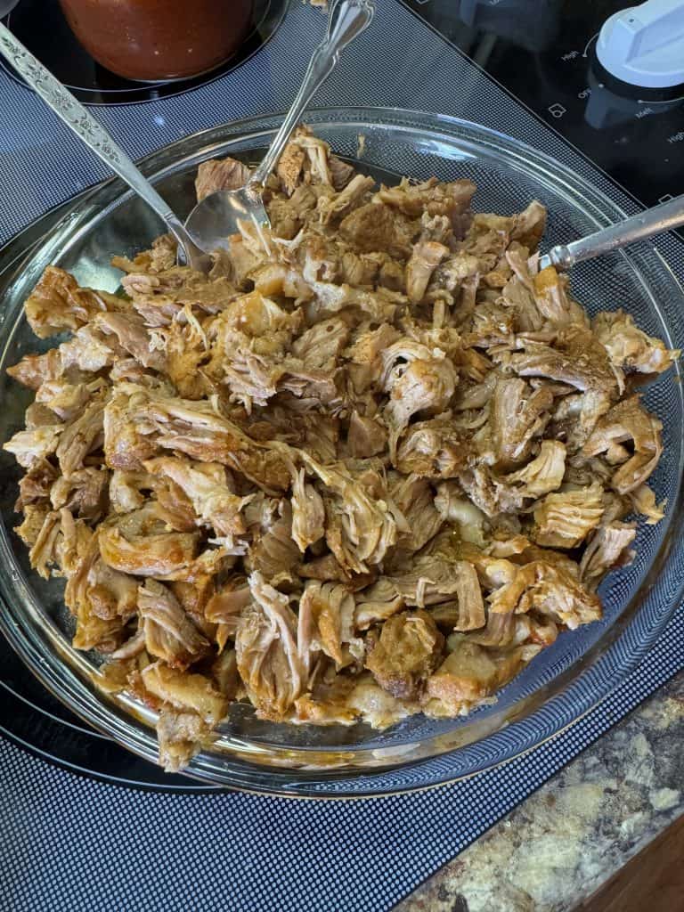 pulled pork sitting in a glass dish