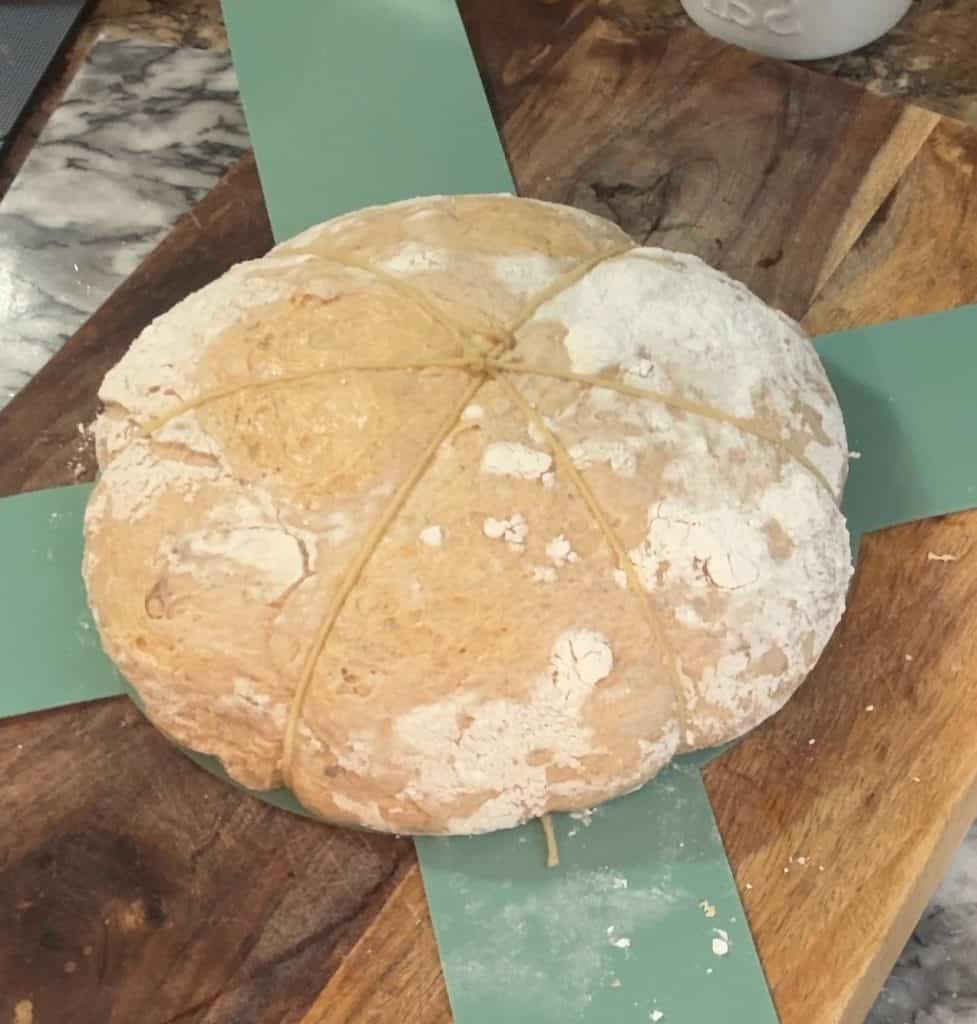 tying twine on sourdough bread to shape it like a pumpkin