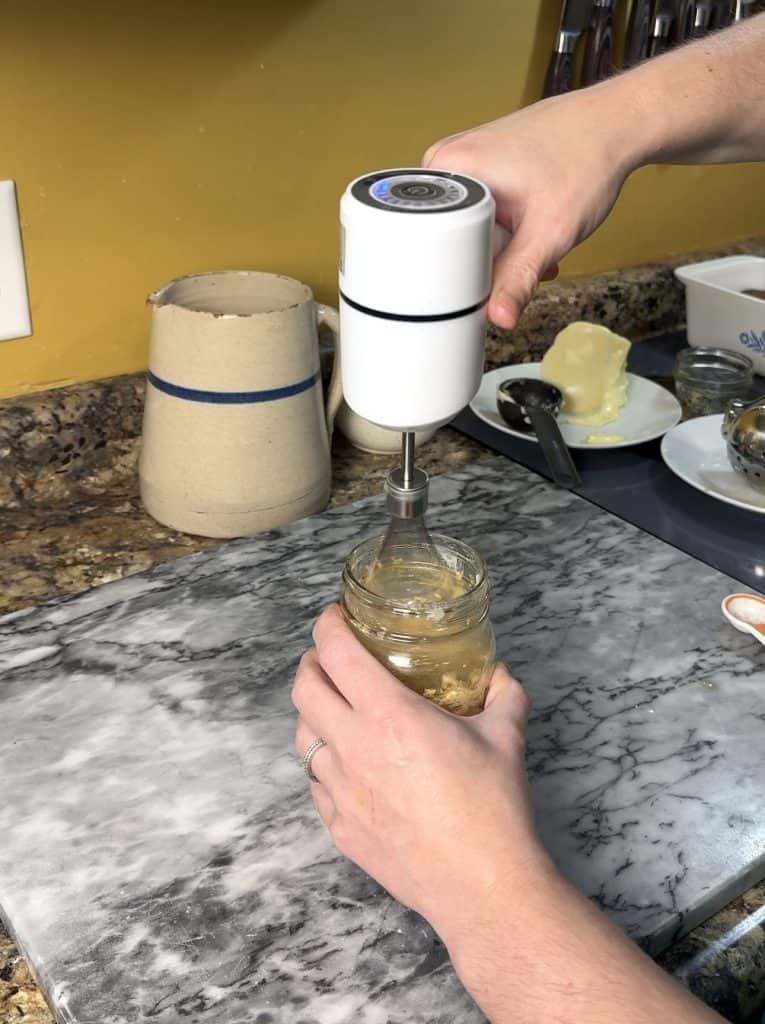using a battery operated hand mixer to mix the ingredients of cowboy butter