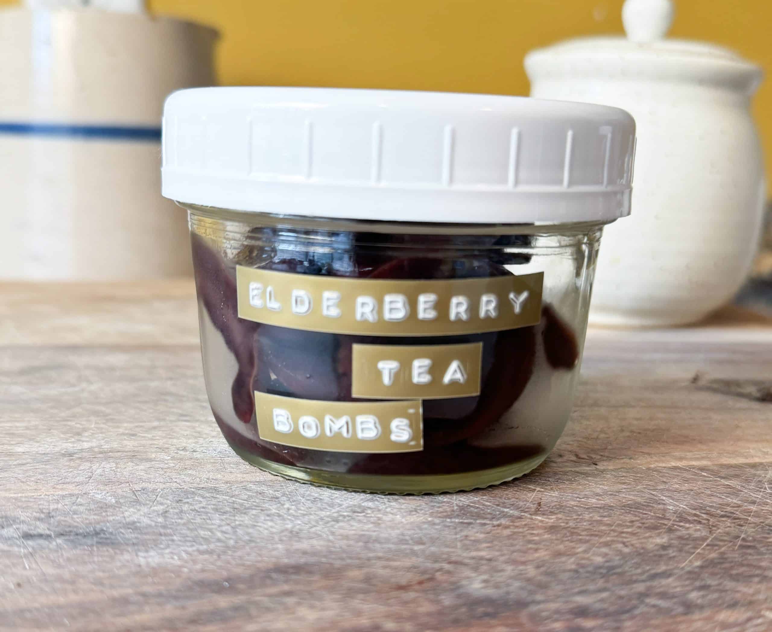 elderberry tea bombs in a mason jar sitting on a wooden cutting board