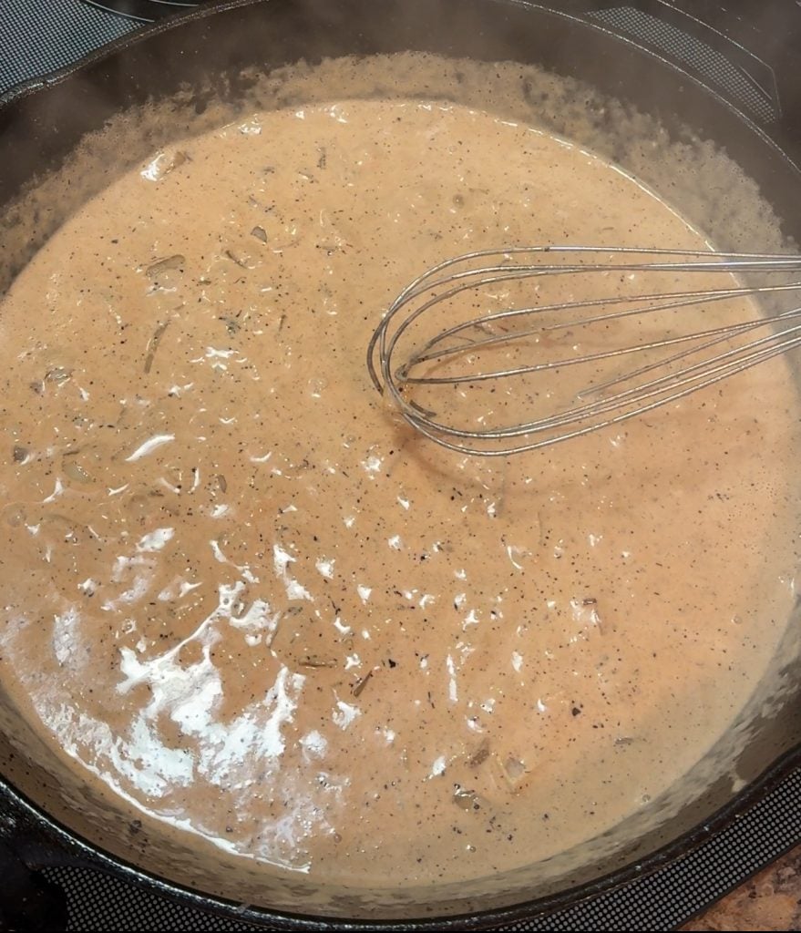 Creamy Tomato Spinach Sauce simmering in a cast iron skillet