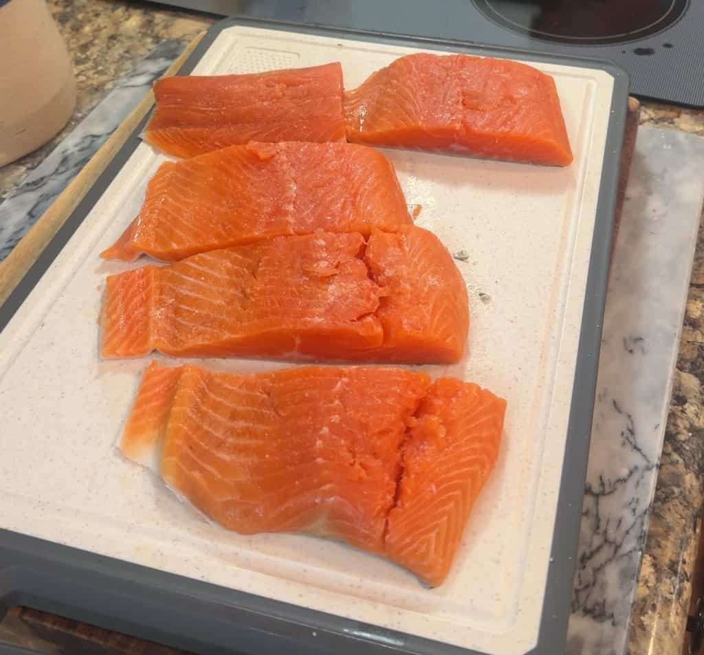 raw steelhead trout fillets on a cutting board