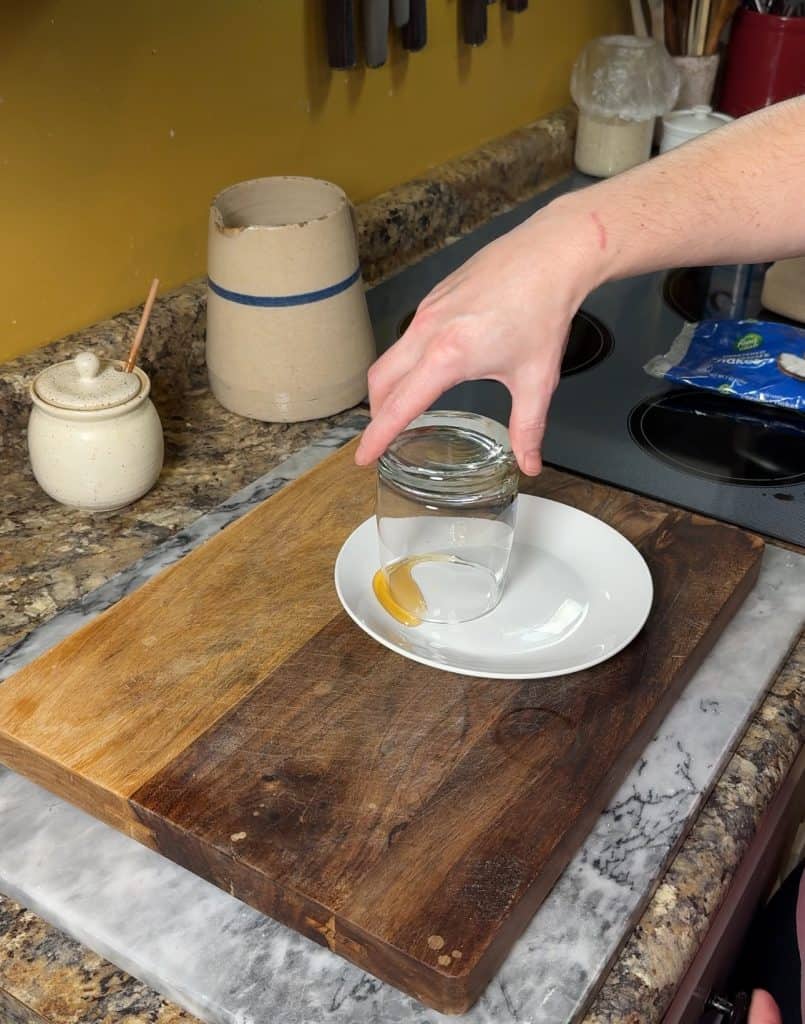 coating the rim of a glass in honey to prepare for a sugared rim