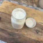 Homemade Ranch Dressing in a mason jar sitting on a wooden cutting board