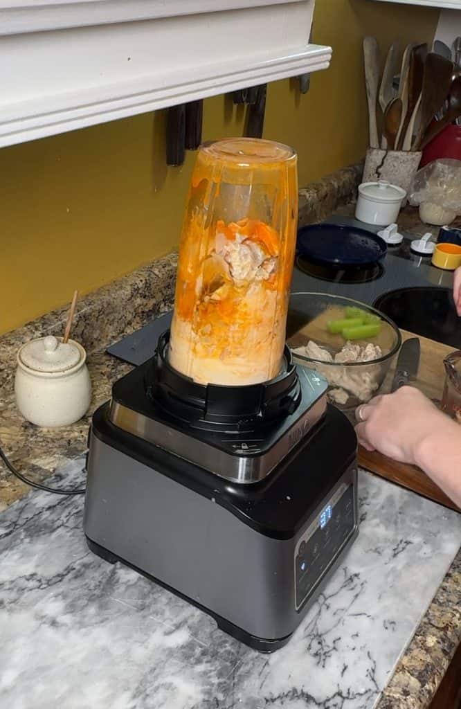 mixing ingredients in a food processor to make hot honey chicken salad