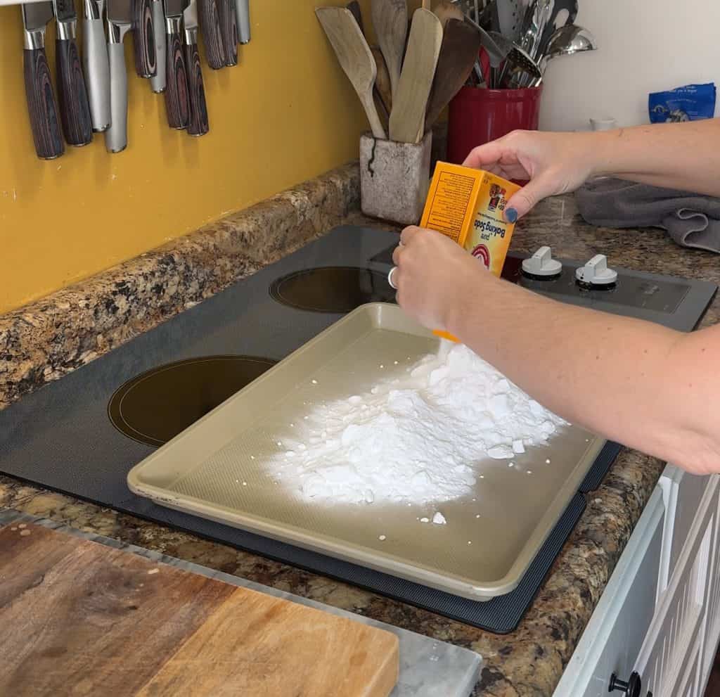 pouring baking soda onto a cooking sheet