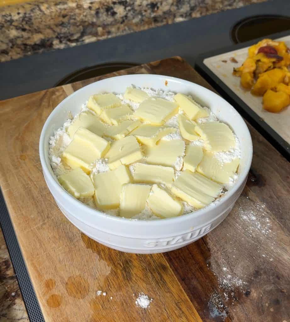 thinly sliced butter on top of the peach cobbler ready to be placed in the instant pot