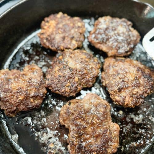 old fashioned hamburger being cooked in a cast iron skillet