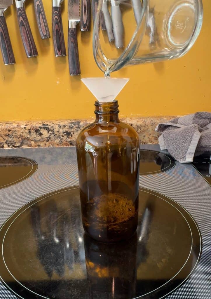 adding vinegar to an amber spray bottle for DIY Wood Cleaner and Polish