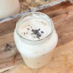 creamy lavender cold foam over iced coffee in a mason jar with lavender buds sprinkled on top
