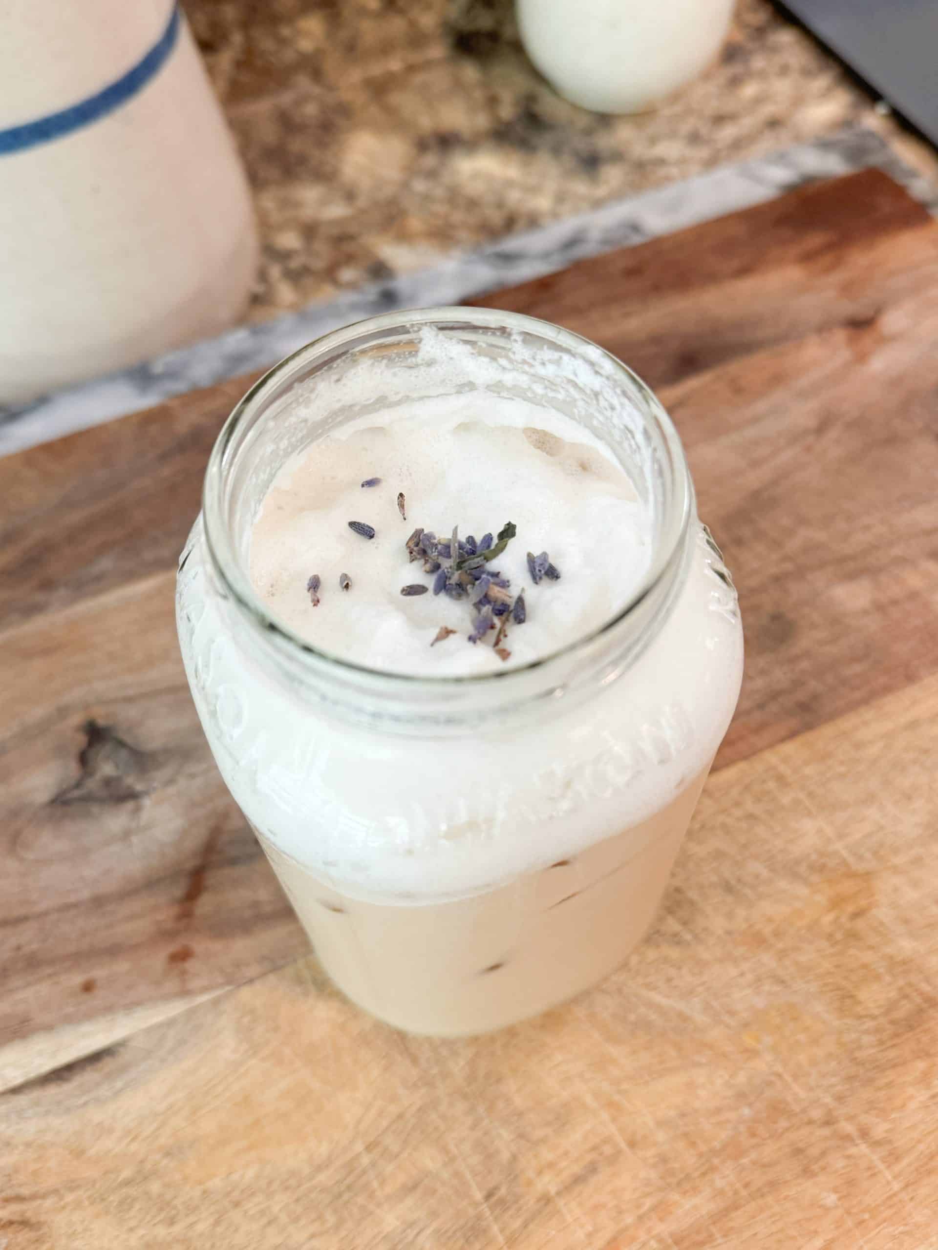 creamy lavender cold foam over iced coffee in a mason jar with lavender buds sprinkled on top