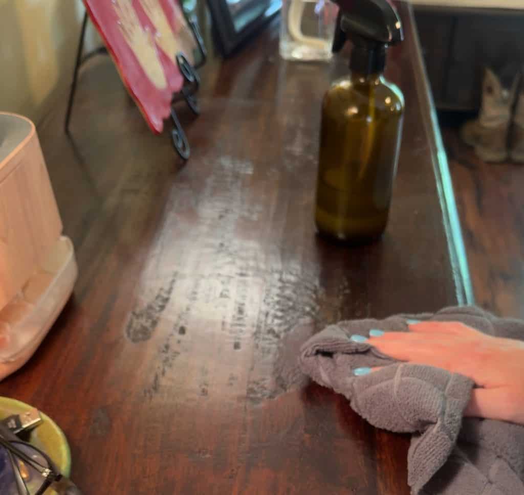 Using DIY Wood Cleaner and Polish to wipe down a wood sofa table