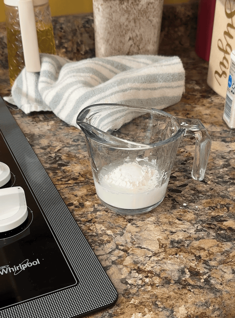 cornstarch and water in a measuring cup sitting on a counter