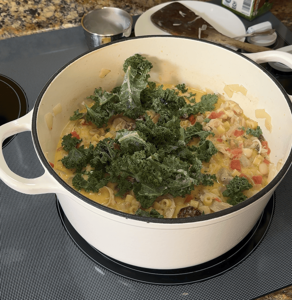 adding kale to creamy tuscan chicken soup