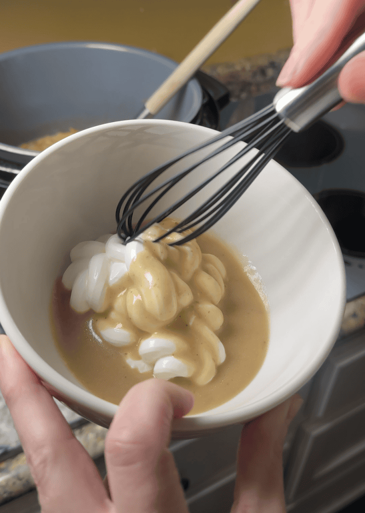 tempering sour cream in a separate bowl with the broth from the beef stroganoff