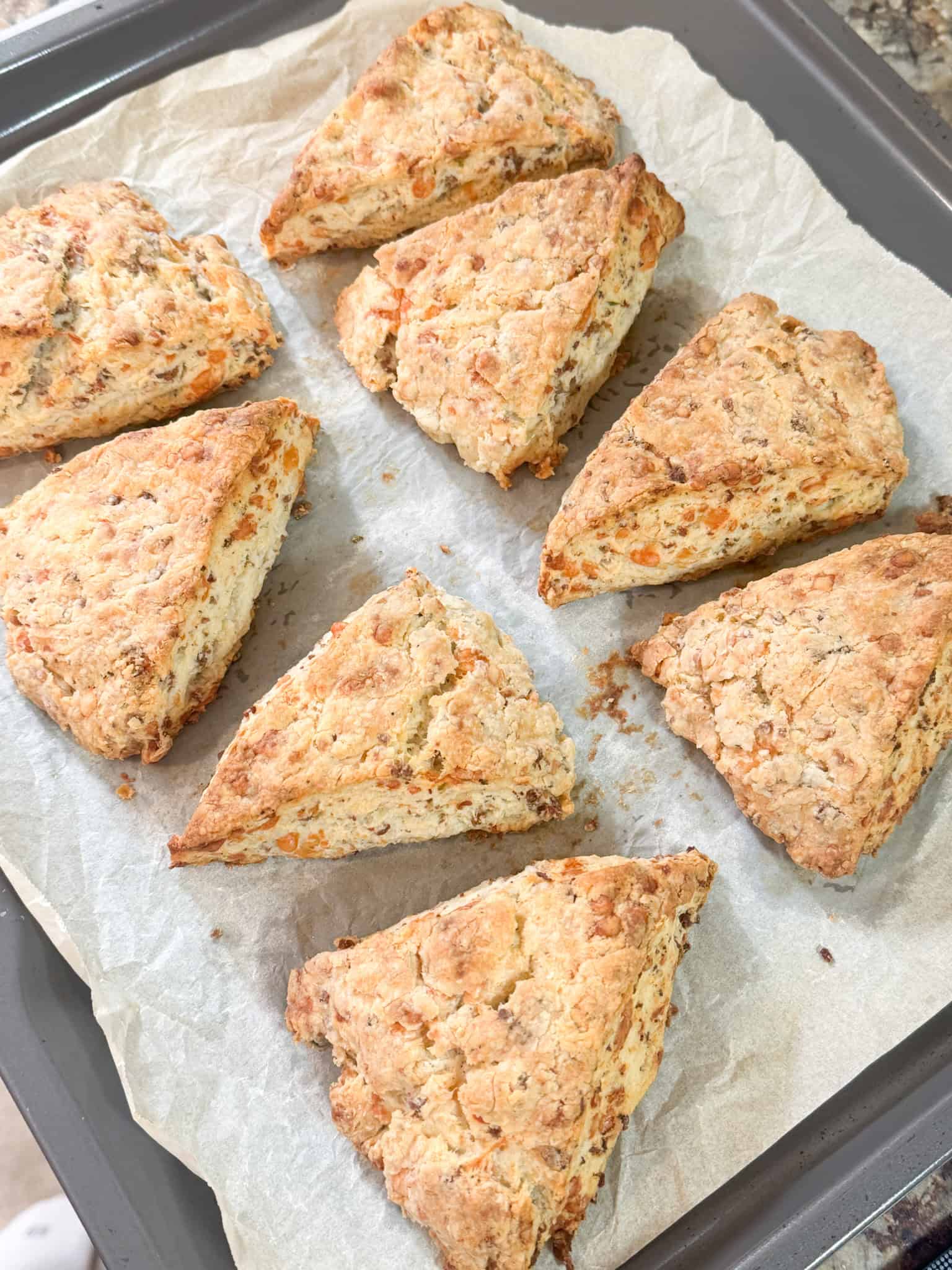 cheesy sausage and rosemary scones cooked golden brown placed on parchment paper