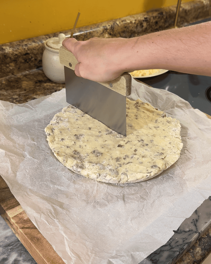 using a bench scraper to cut the dough into 8 equal wedges