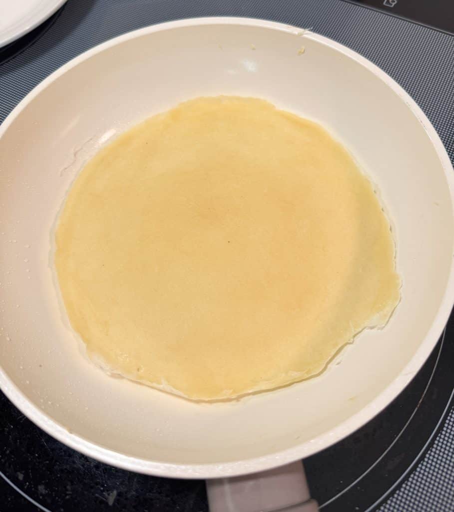 egg roll wrapper ready to be flipped in a pan